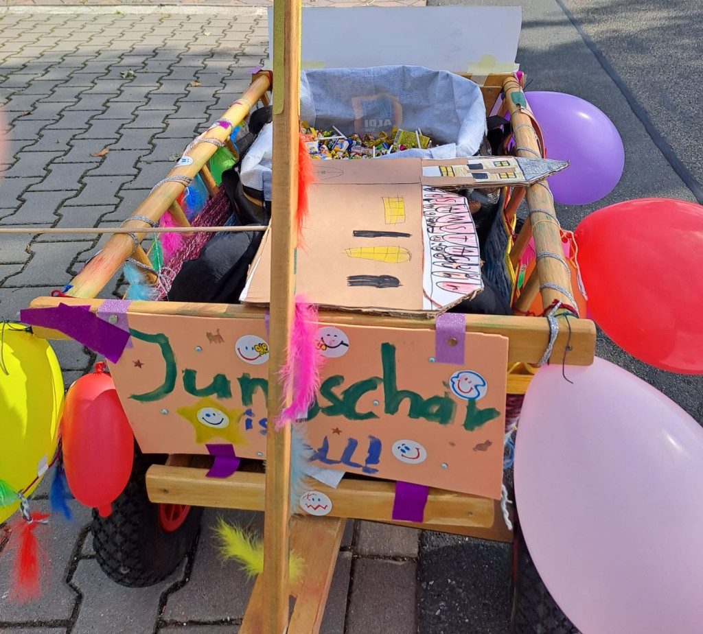Geschmückter Bollerwagen mit Jungscharbild