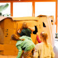 Kinder bauen aus Pappkartons eine Arche